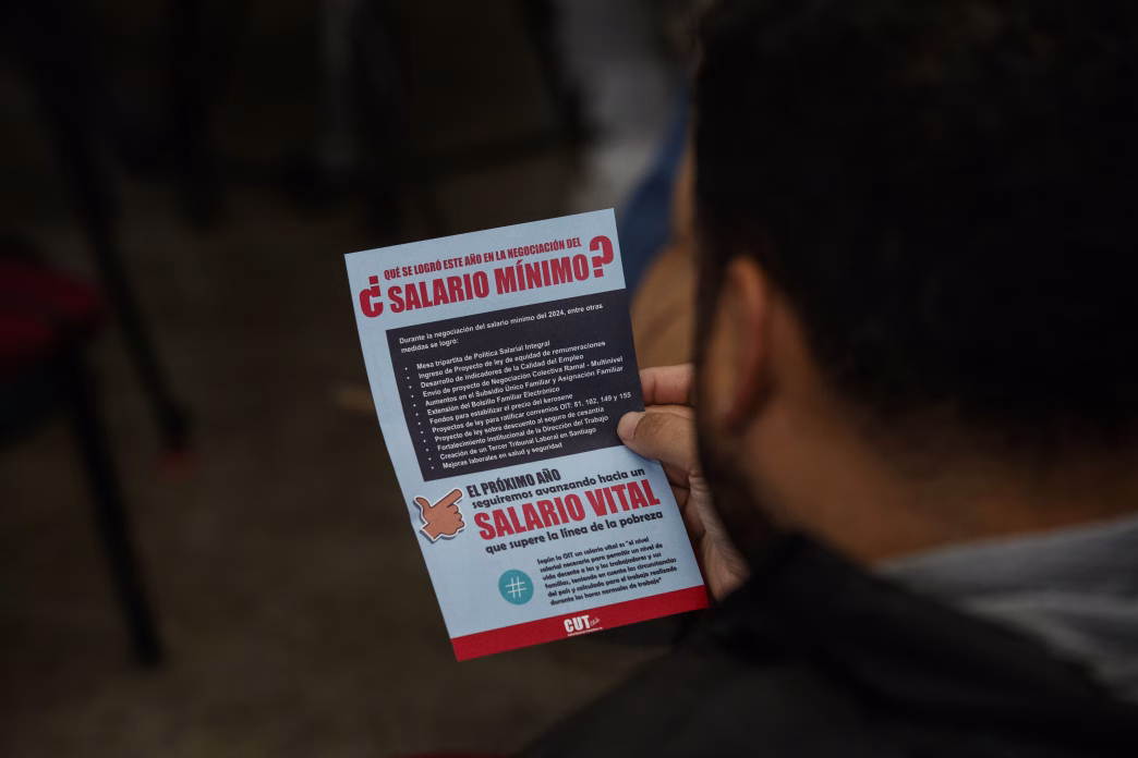Una persona leyendo un folleto sobre el salario mínimo informado por la CUT